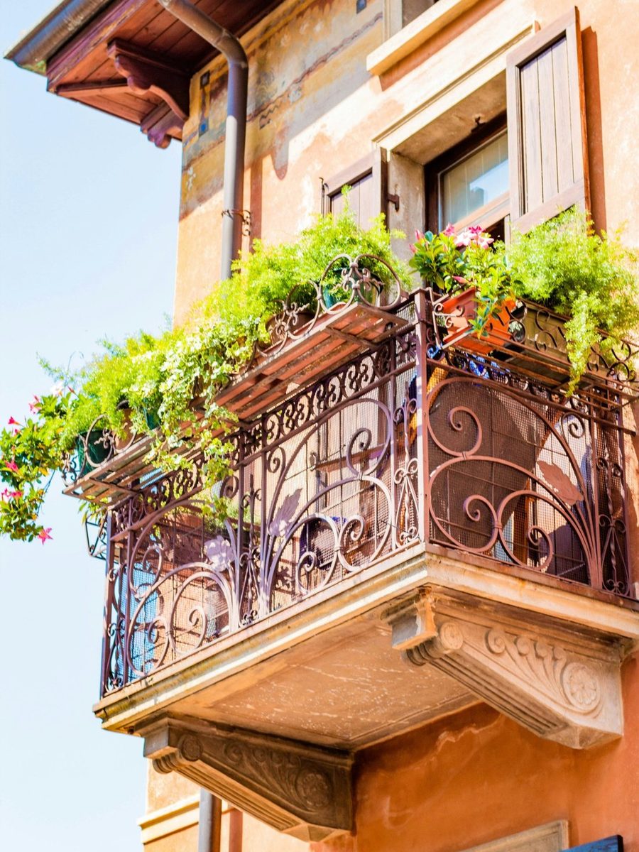A wrought-iron balcony above a lakeside street on Lake Garda